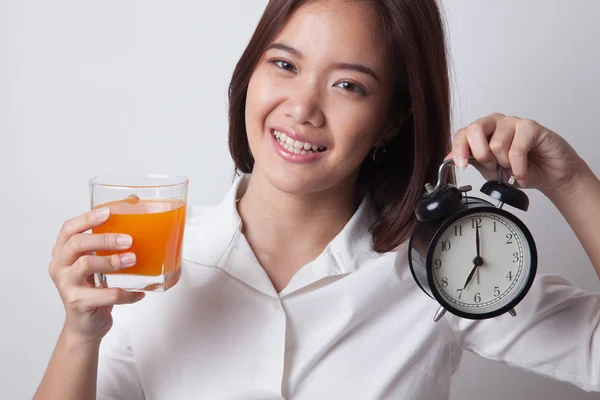 Asiatische Frau mit einer Uhr trinken Orangensaft. — Stockfoto