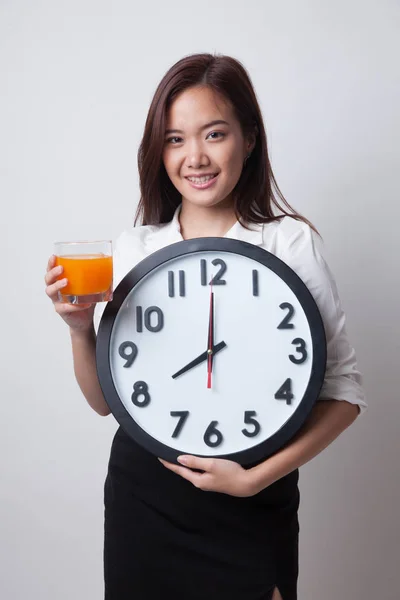 Mulher asiática com um relógio beber suco de laranja . — Fotografia de Stock