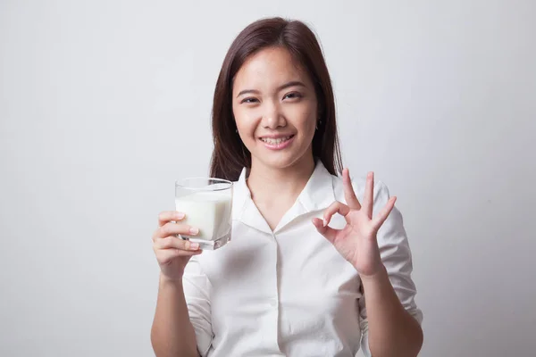 Friska asiatisk kvinna dricka ett glas mjölk visar Ok tecken. — Stockfoto