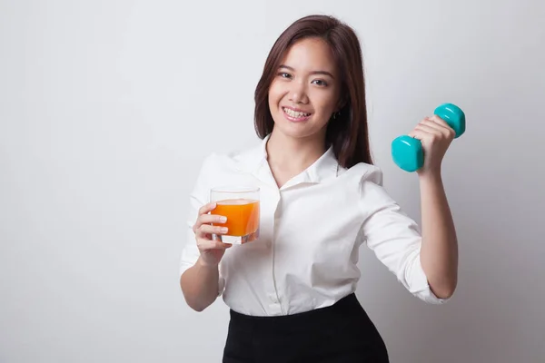 Jovem mulher asiática com haltere beber suco de laranja . — Fotografia de Stock