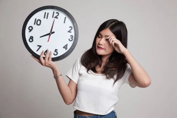 Sleepy joven asiática mujer con un reloj en la mañana . — Foto de Stock