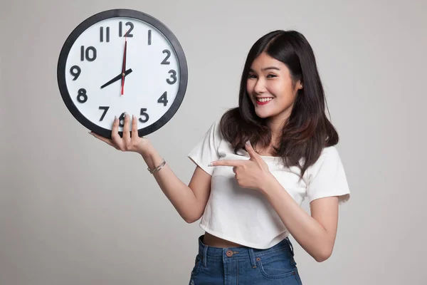 年轻的亚裔女子点到时钟. — 图库照片
