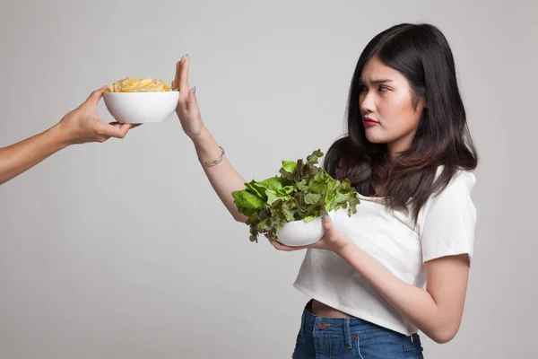 Ung asiatisk kvinna med sallad säga nej till potatischips. — Stockfoto