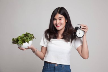 Saat ve salata ile genç Asyalı kadın.