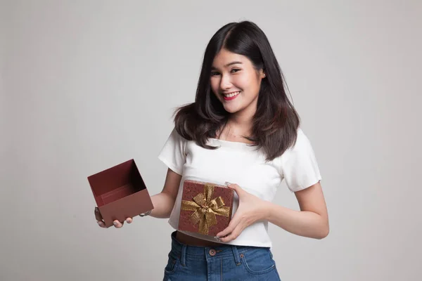 Fiatal ázsiai nő nyit egy arany ajándék doboz. — Stock Fotó