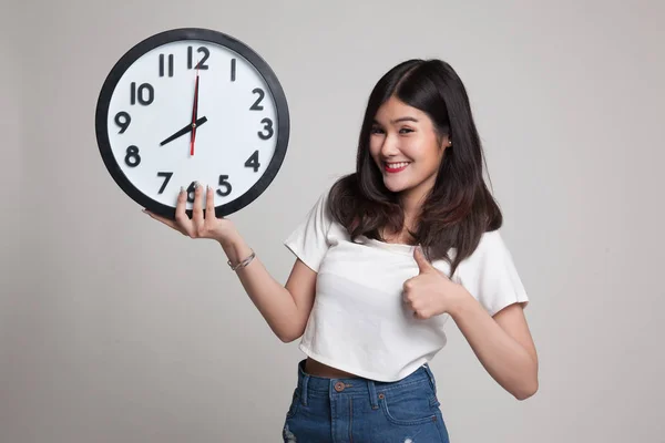 Joven mujer asiática pulgares arriba con un reloj . —  Fotos de Stock