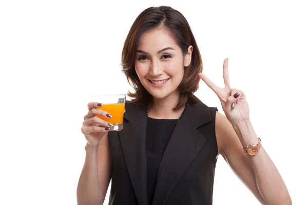 Junge asiatische Frau zeigt Siegeszeichen trinken Orangensaft. — Stockfoto