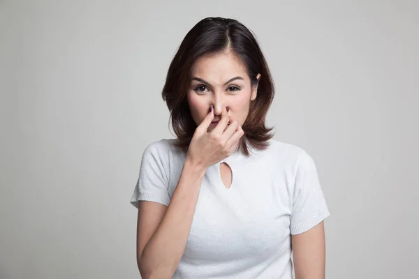 Giovane donna asiatica tenendo il naso a causa di un cattivo odore . — Foto Stock