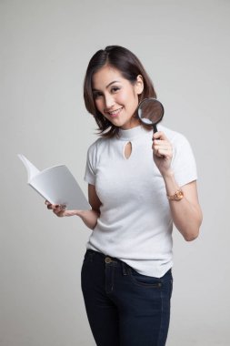 Bir kitap ve Büyüteç ile Asyalı kadın.