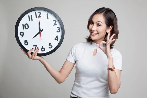 Joven asiática show OK con un reloj . —  Fotos de Stock