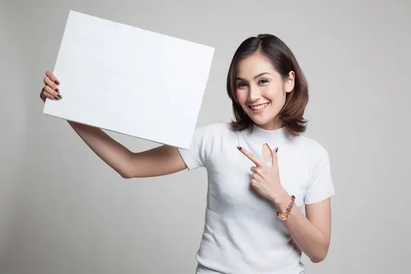 Jonge Aziatische vrouw punt aan leeg teken. — Stockfoto