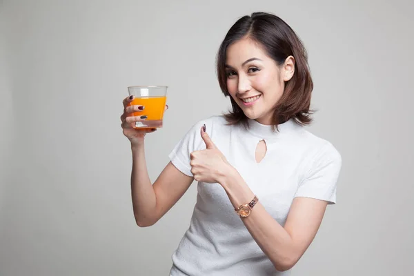 Tineri asiatic femeie thumbs în sus bea suc de portocale . — Fotografie, imagine de stoc