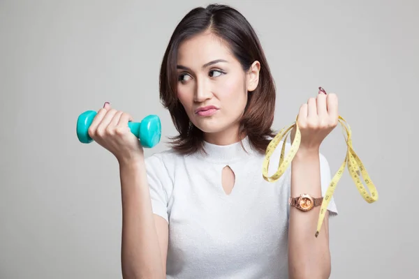 Esausta donna asiatica con manubri e nastro di misurazione . — Foto Stock