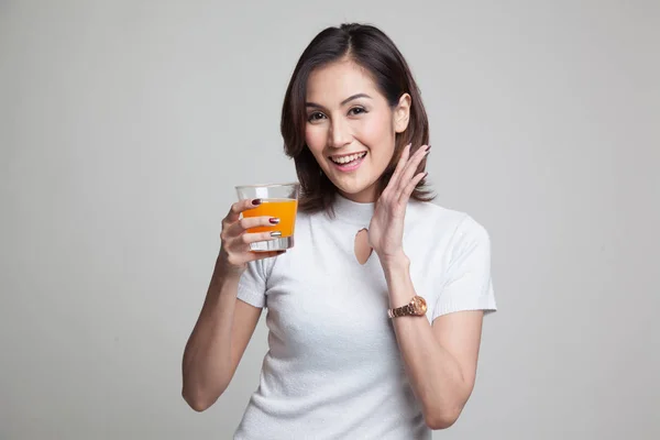 Jovem mulher asiática feliz beber suco de laranja . — Fotografia de Stock