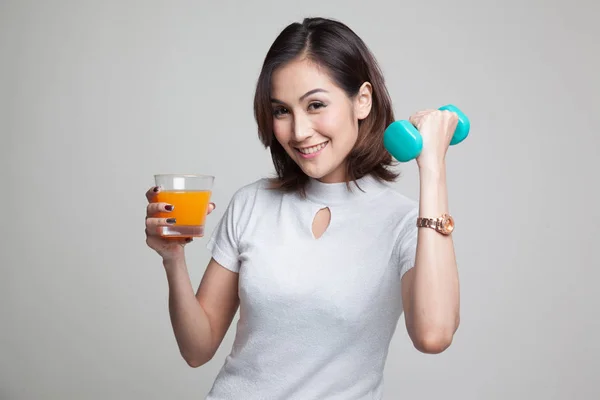 Young Asian woman with dumbbell drink orange juice. — Stock Photo, Image