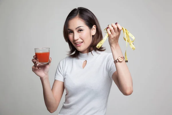 Mulher asiática com suco de tomate e fita métrica . — Fotografia de Stock