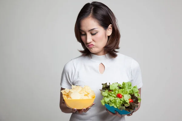 Jonge Aziatische vrouw met aardappel frites en salade. — Stockfoto