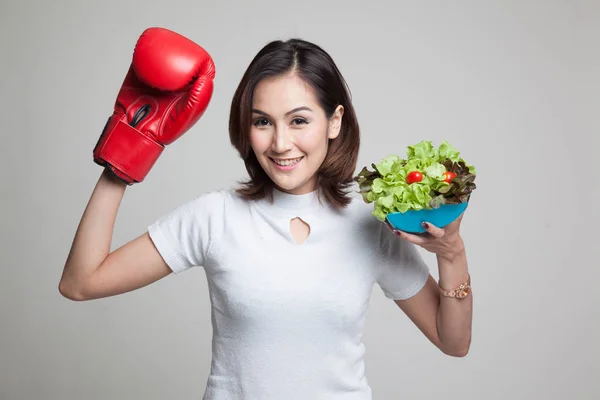 Giovane donna asiatica con guanto da boxe e insalata . — Foto Stock
