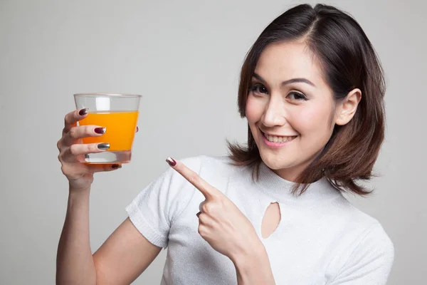 Jonge Aziatische vrouw punt aan jus d'orange. — Stockfoto