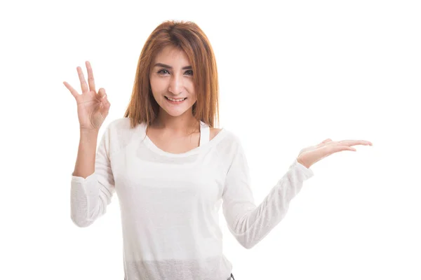 Schön junge asiatische Frau zeigen Handfläche Hand und ok Zeichen. — Stockfoto