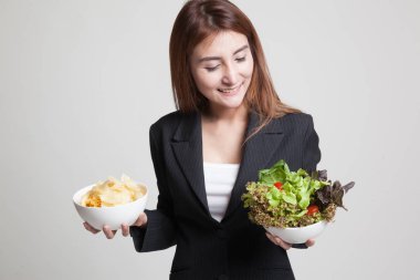 Patates kızartması ve salata ile genç Asyalı kadın.