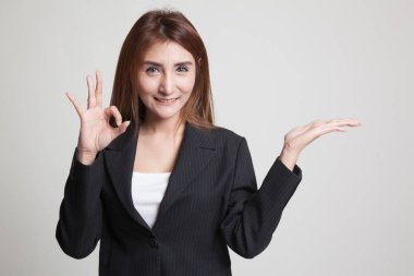 Güzel genç Asyalı kadın göstermek palm el ve Ok işareti.