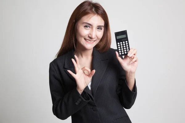 Asiatische Frau zeigen ok mit Taschenrechner. — Stockfoto