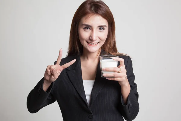 Gesunde asiatische Frau, die ein Glas Milch trinkt, zeigt Siegeszeichen. — Stockfoto