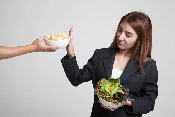 Ung asiatisk kvinna med sallad säga nej till potatischips. — Stockfoto