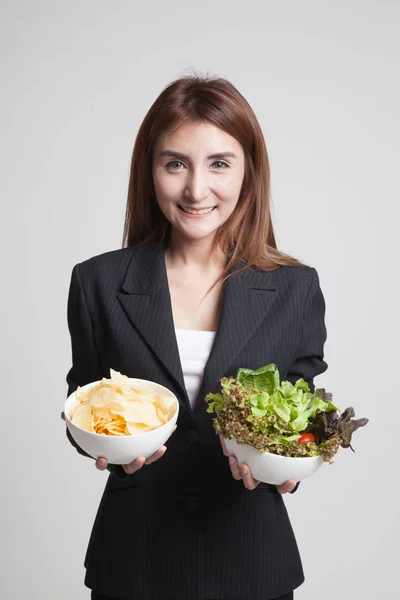 Jonge Aziatische vrouw met aardappel frites en salade. — Stockfoto