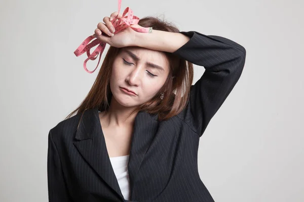 Unhappy young Asian woman with measuring tape. — Stock Photo, Image