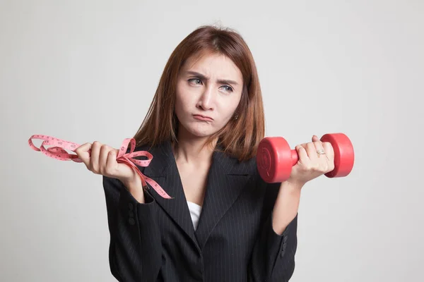 Mujer asiática agotada con mancuernas y cinta métrica . — Foto de Stock