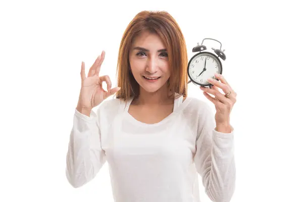 Young Asian woman show OK with a clock. — Stock Photo, Image