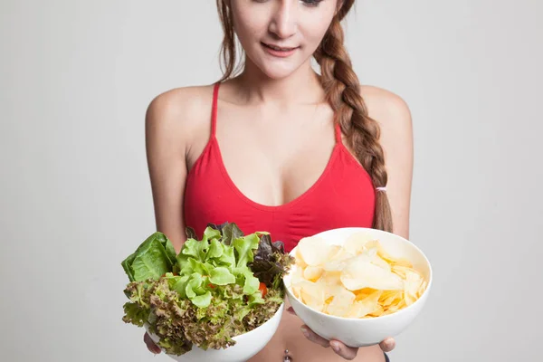 Asyalı sağlıklı kız salata ve patates cipsi kadar yakın. — Stok fotoğraf