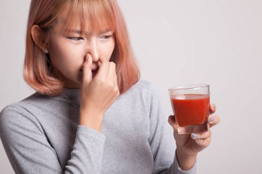 Genç Asyalı kadın nefret domates suyu.