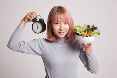 Saat ve salata ile genç Asyalı kadın.