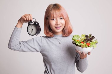 Saat ve salata ile genç Asyalı kadın.
