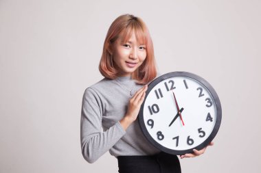 Saati olan genç Asyalı kadın..