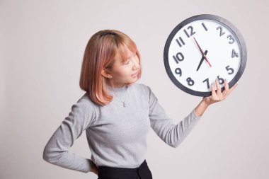 Saati olan genç Asyalı kadın..