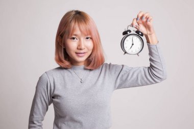 Saati olan genç Asyalı kadın..