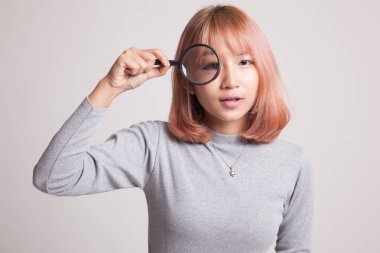 Bir büyüteç ile genç Asyalı kadın.