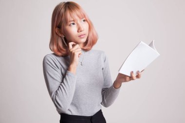 Bir kitapla genç Asyalı kadın düşünüyor.