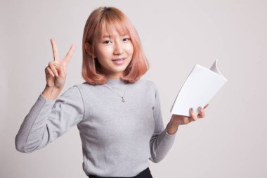 Genç Asyalı kadın Haritayı victor işareti bir kitapla.