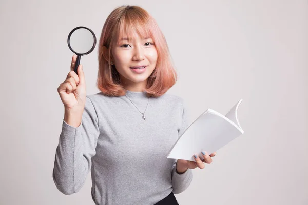 Donna asiatica con libro e lente d'ingrandimento . — Foto Stock