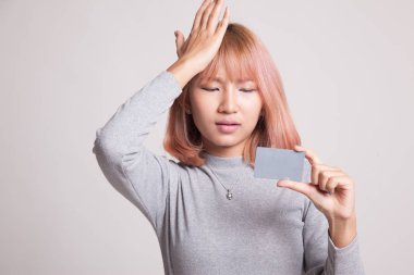 Genç Asyalı kadın baş ağrısı boş bir kart ile.