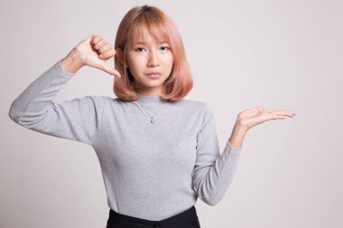 Genç Asyalı kadın göstermek palm el ve başparmak aşağı.