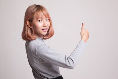 Genç Asyalı kadın sıra arka başparmak yukarıya.