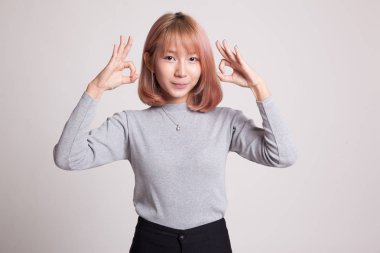 Asyalı kadın Çift Ok işaret ve gülümseme göster.