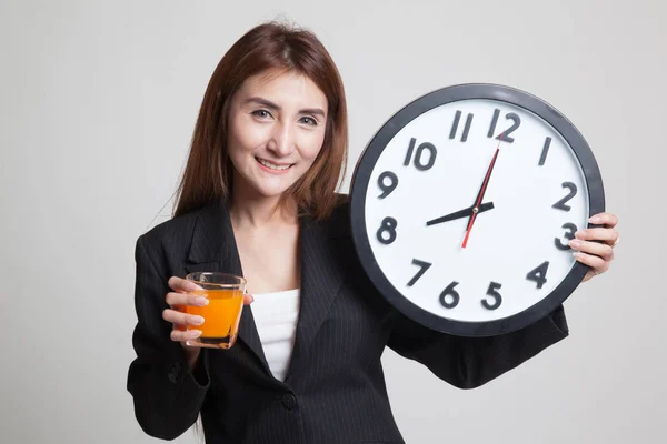 Mulher asiática com um relógio beber suco de laranja . — Fotografia de Stock