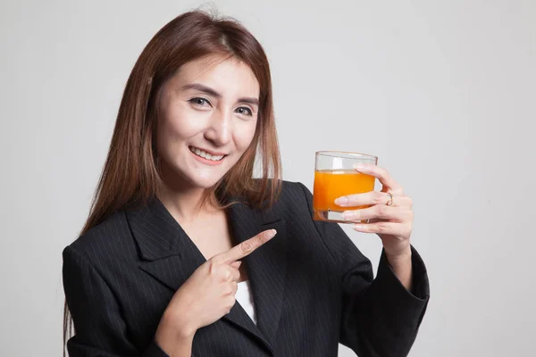 Junge Asiatin zeigt auf Orangensaft. — Stockfoto